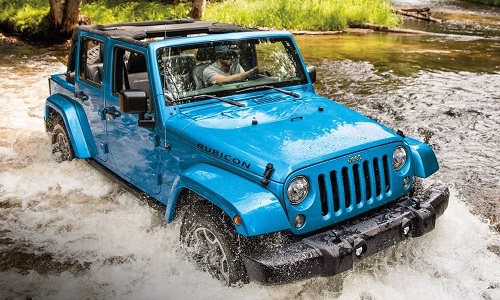 a blue jeep wrangler crossing a canal