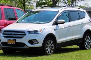 a white ford escape parked in the lawn